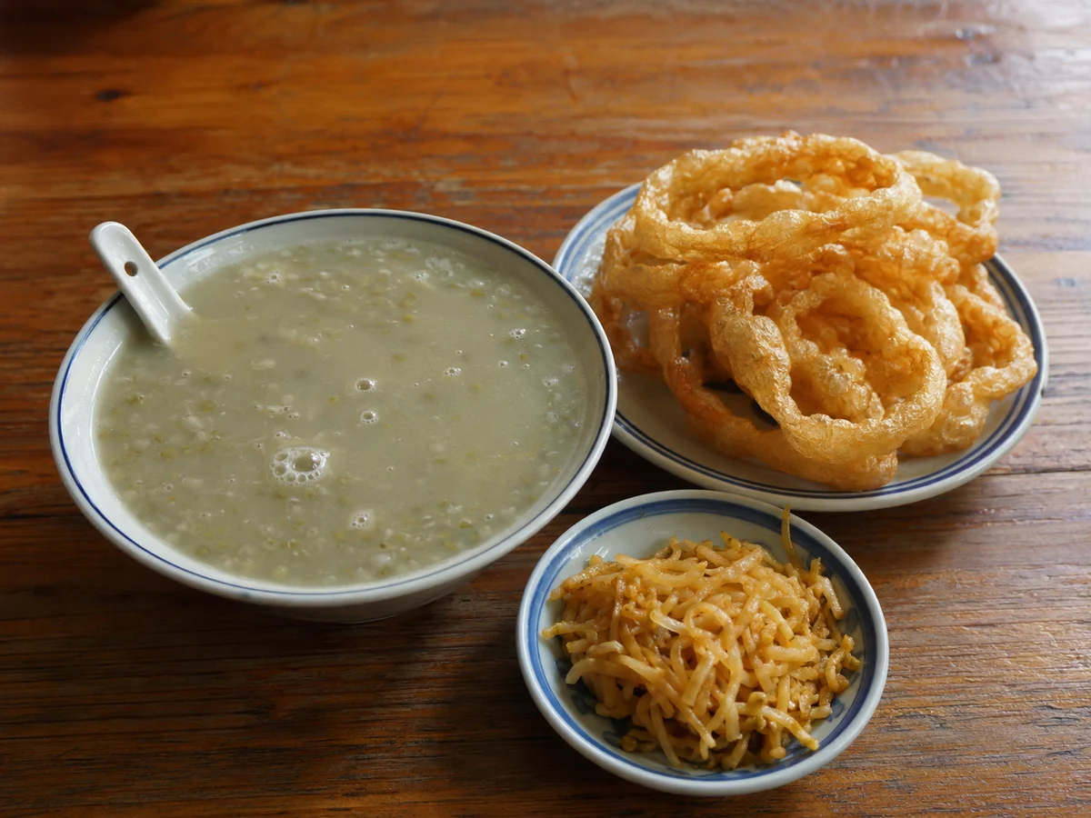Old Beijing fermented mung-bean drink douzhir served with crisp fried jiaoquan rings and pickles