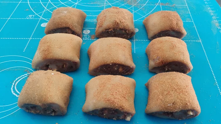 Nine homemade ludagun rolls with glutinous-rice wrappers, dark red-bean filling and roasted soybean flour on a blue pastry mat