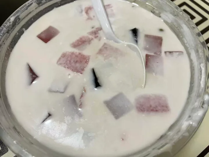 A creamy qingbuliang with purple and dark jelly cubes in a coconut-milk base