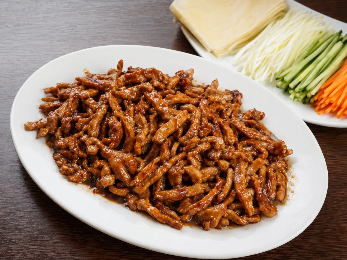 Beijing-style shredded pork in sweet bean sauce served with tofu-skin wrappers and scallions
